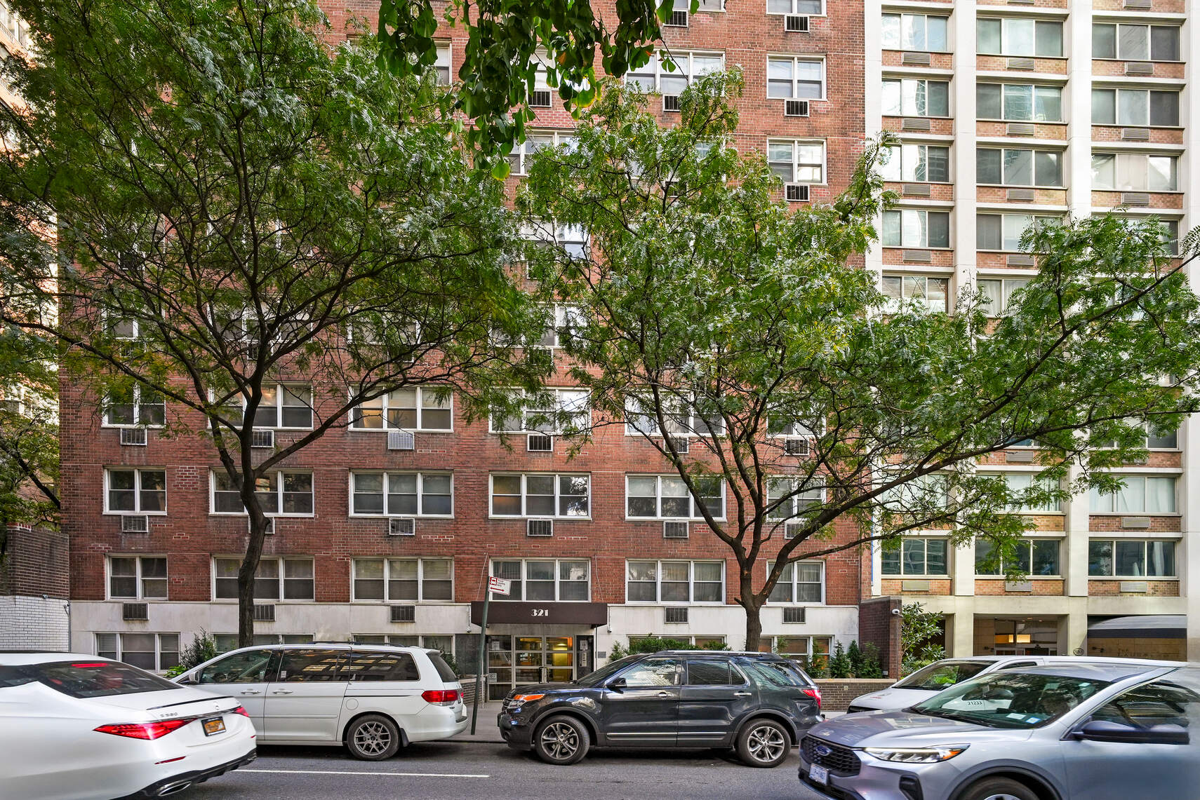 321 East 45th Street, Unit 1F Manhattan, NY 10017 - Photo 10 of 14 a car parked in front of a brick building