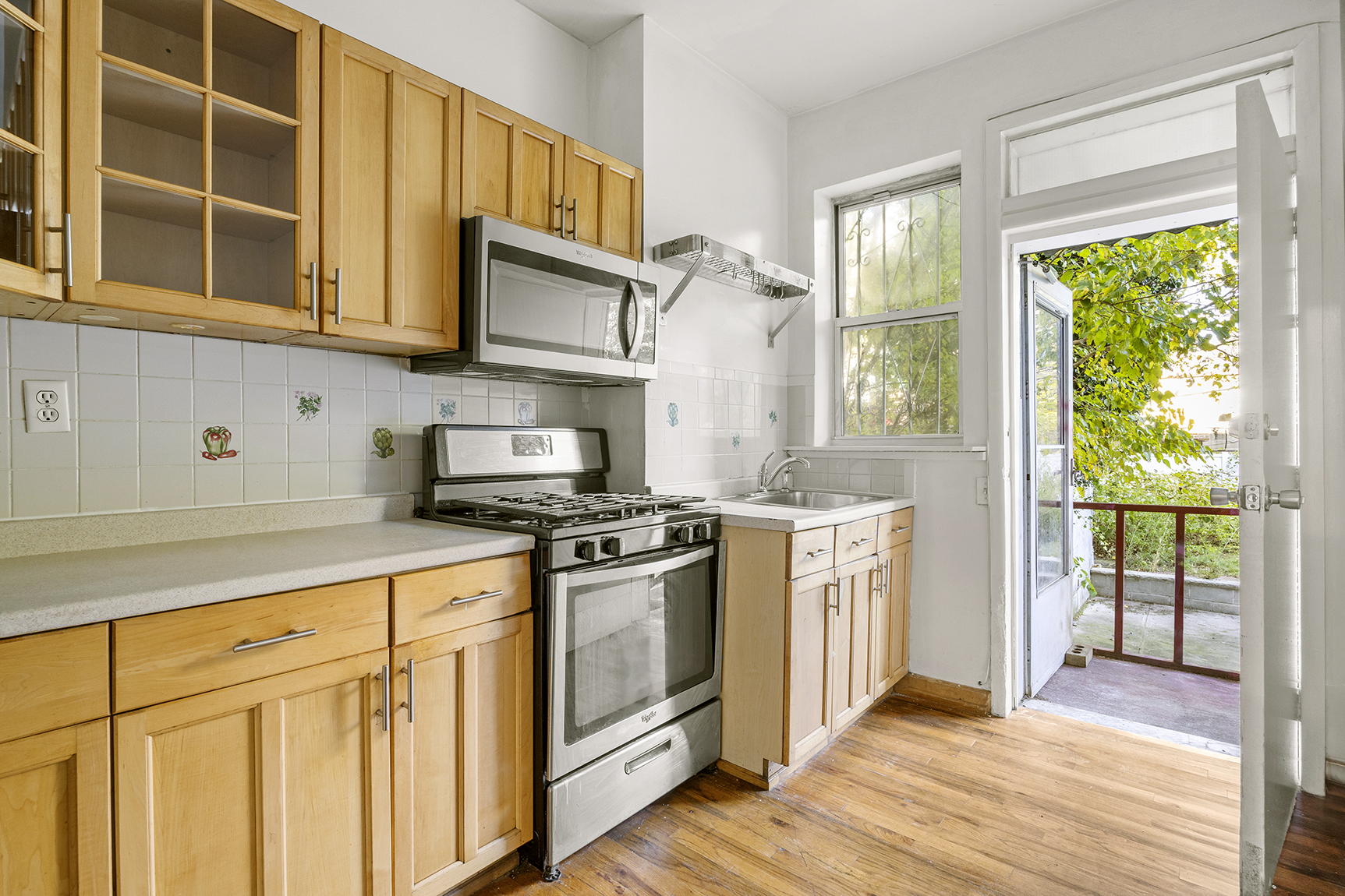 1437 Lincoln Place Brooklyn, NY 11213 - Photo 3 of 12 a kitchen with stainless steel appliances granite countertop a stove a sink and white cabinets with wooden floors