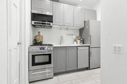 a kitchen with stainless steel appliances granite countertop a stove a microwave and a refrigerator