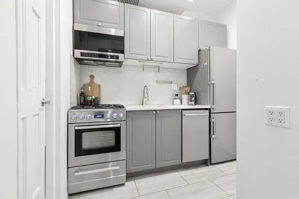 a kitchen with stainless steel appliances granite countertop a stove a microwave and a refrigerator