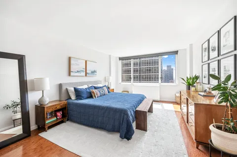 a bedroom with a bed and a potted plant