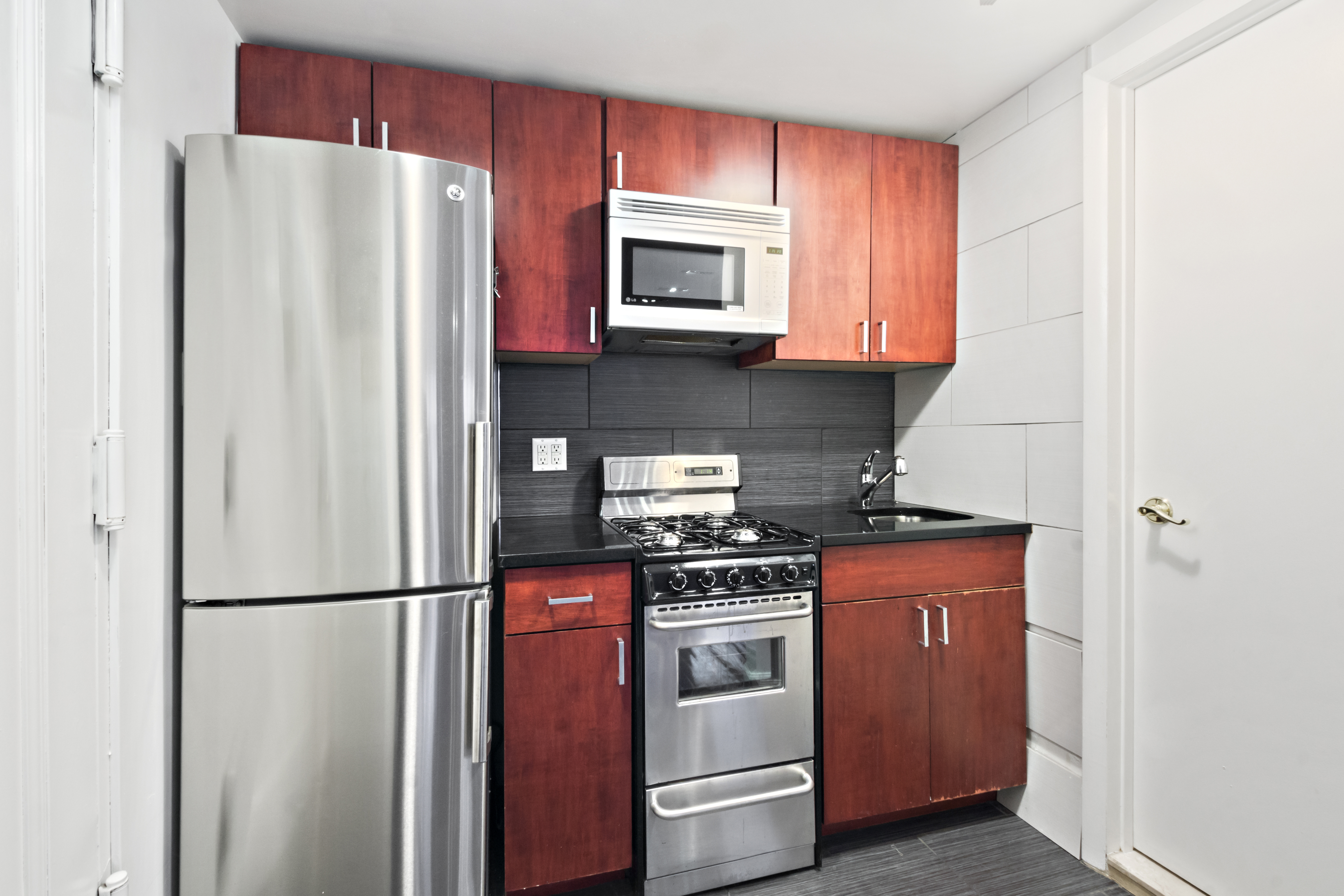 54 Jane Street Manhattan, NY 10014 - Photo 25 of 26 a kitchen with stainless steel appliances granite countertop a refrigerator sink and stove