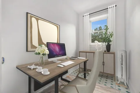 a view of a workspace with furniture and a window