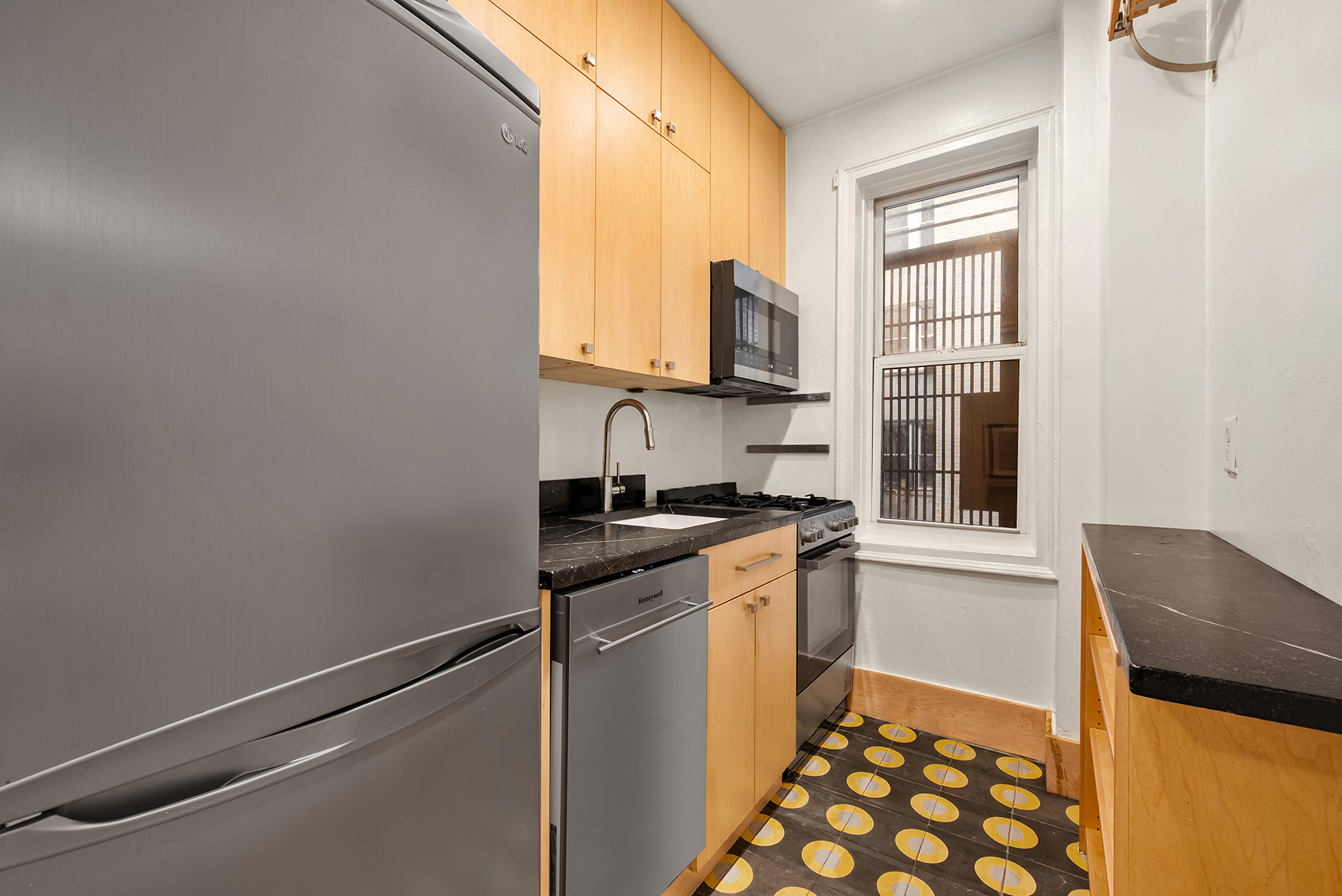 55 Eastern Parkway, Unit 1D Brooklyn, NY 11238 - Photo 6 of 8 a kitchen with a sink cabinets and a window