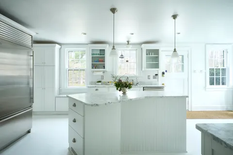 a kitchen with kitchen island a counter top space appliances and a cabinets
