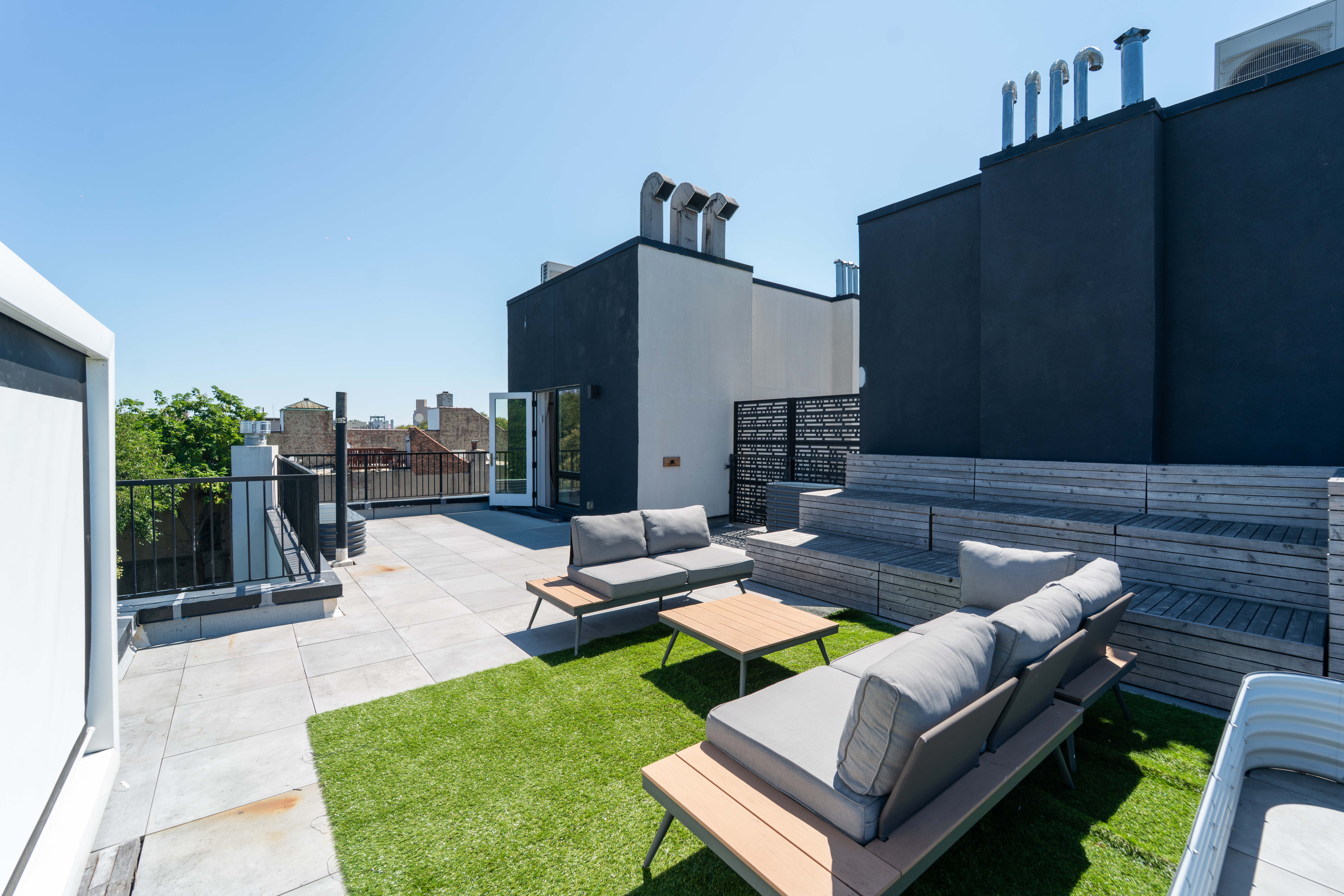 a view of a backyard with couches table and chairs and potted plants