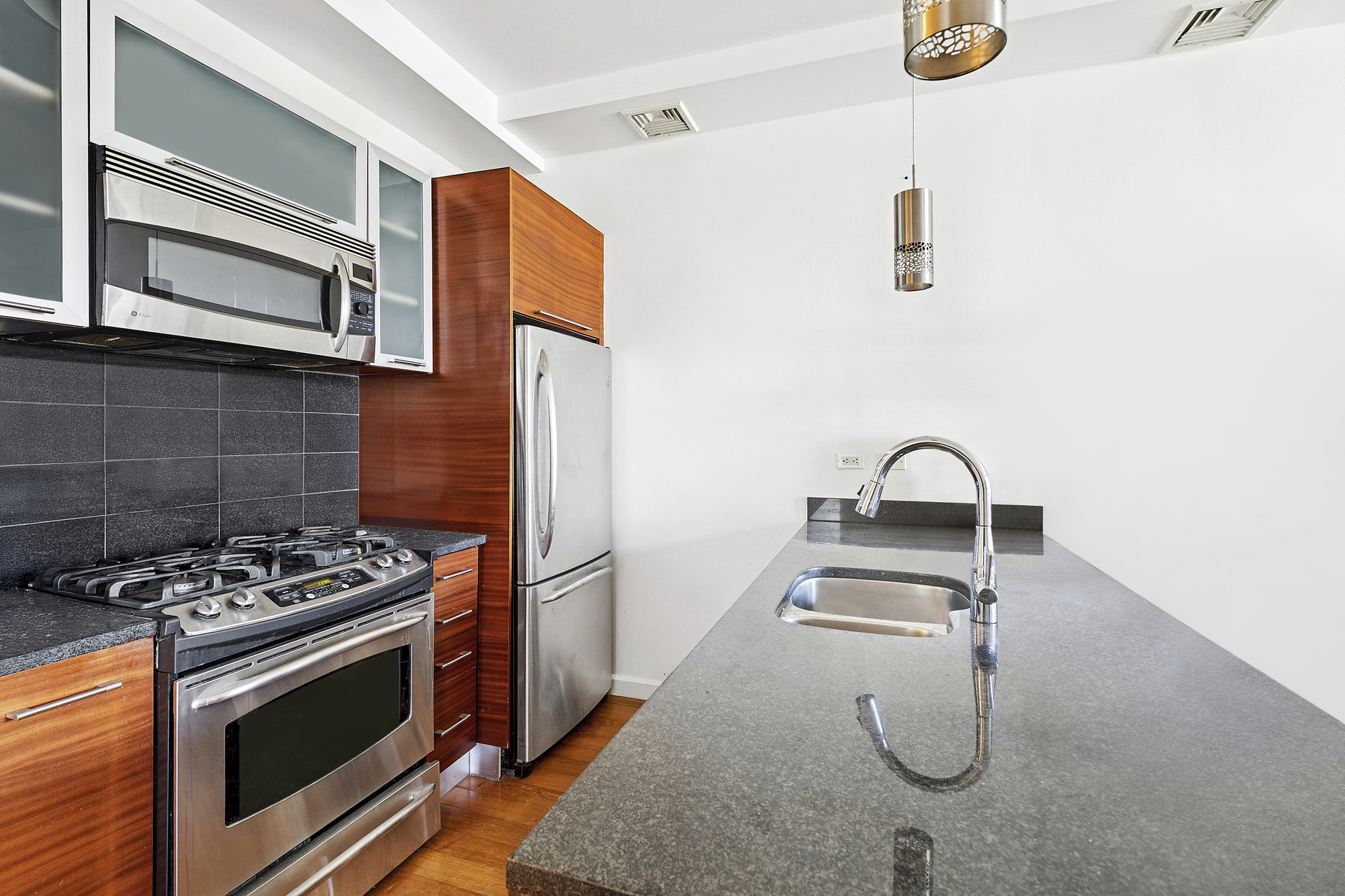 78 Roebling Street, Unit 2B Brooklyn, NY 11211 - Photo 2 of 7 a kitchen with granite countertop a stove and a sink