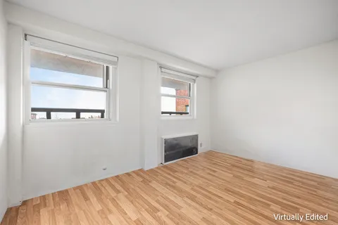 a view of a room with wooden floor and a bathroom