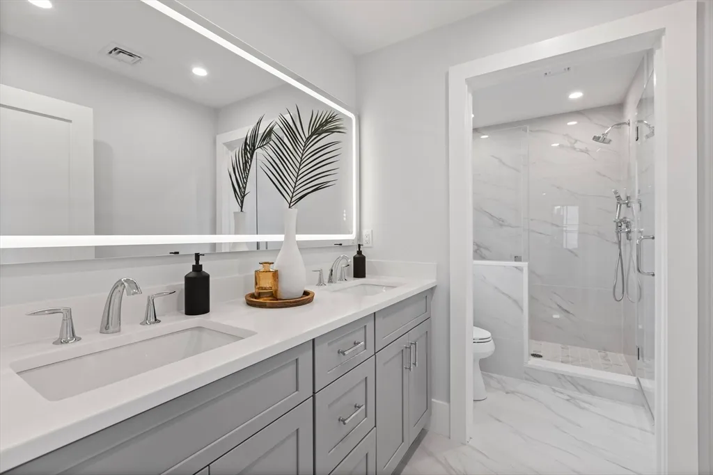 a bathroom with a sink a toilet and shower