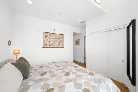 a bedroom with a bed and a painting on the wall