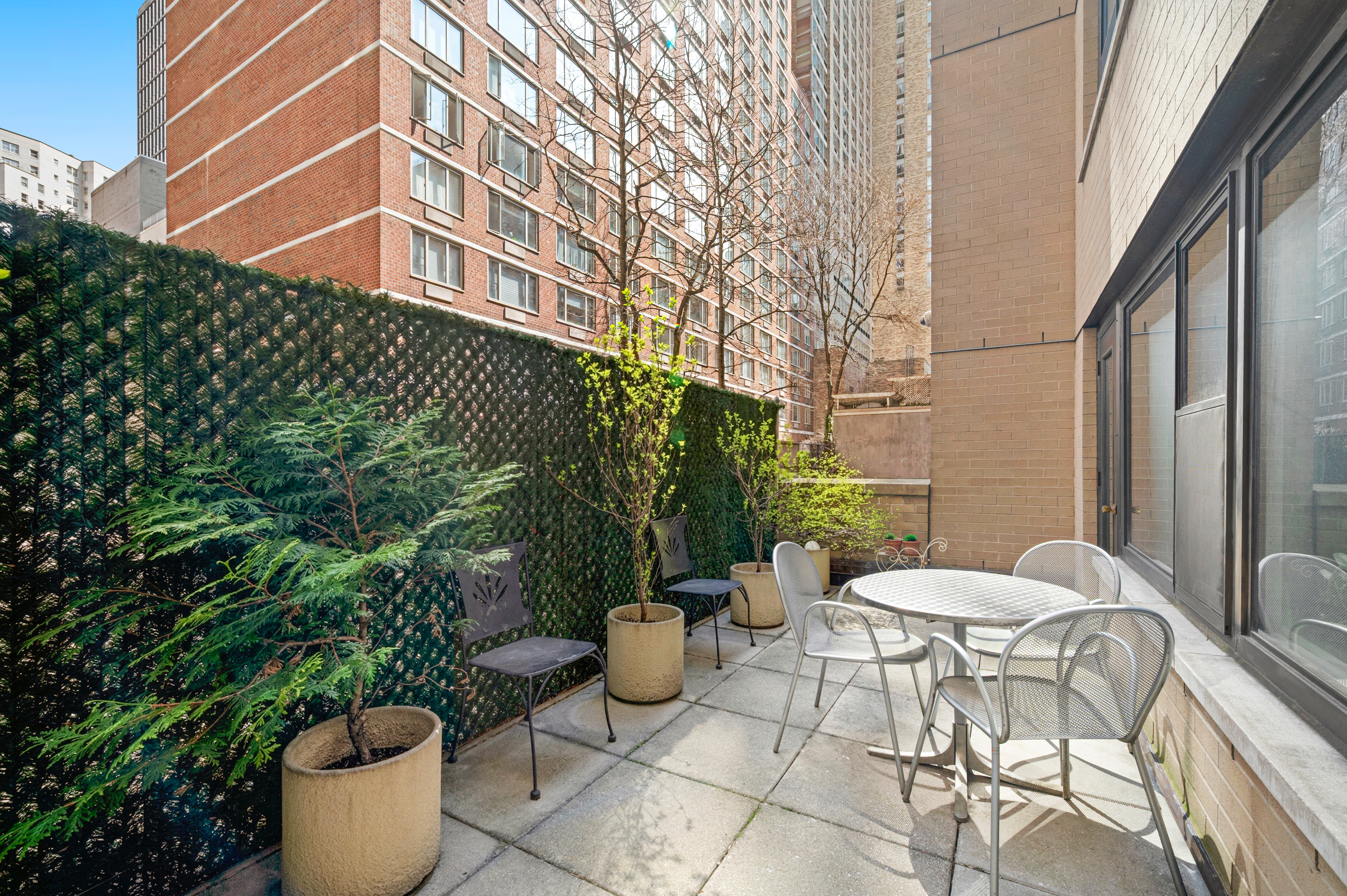 165 West 66th Street, Unit 2R Manhattan, NY 10023 - Photo 5 of 6 a view of a patio with table and chairs and potted plants