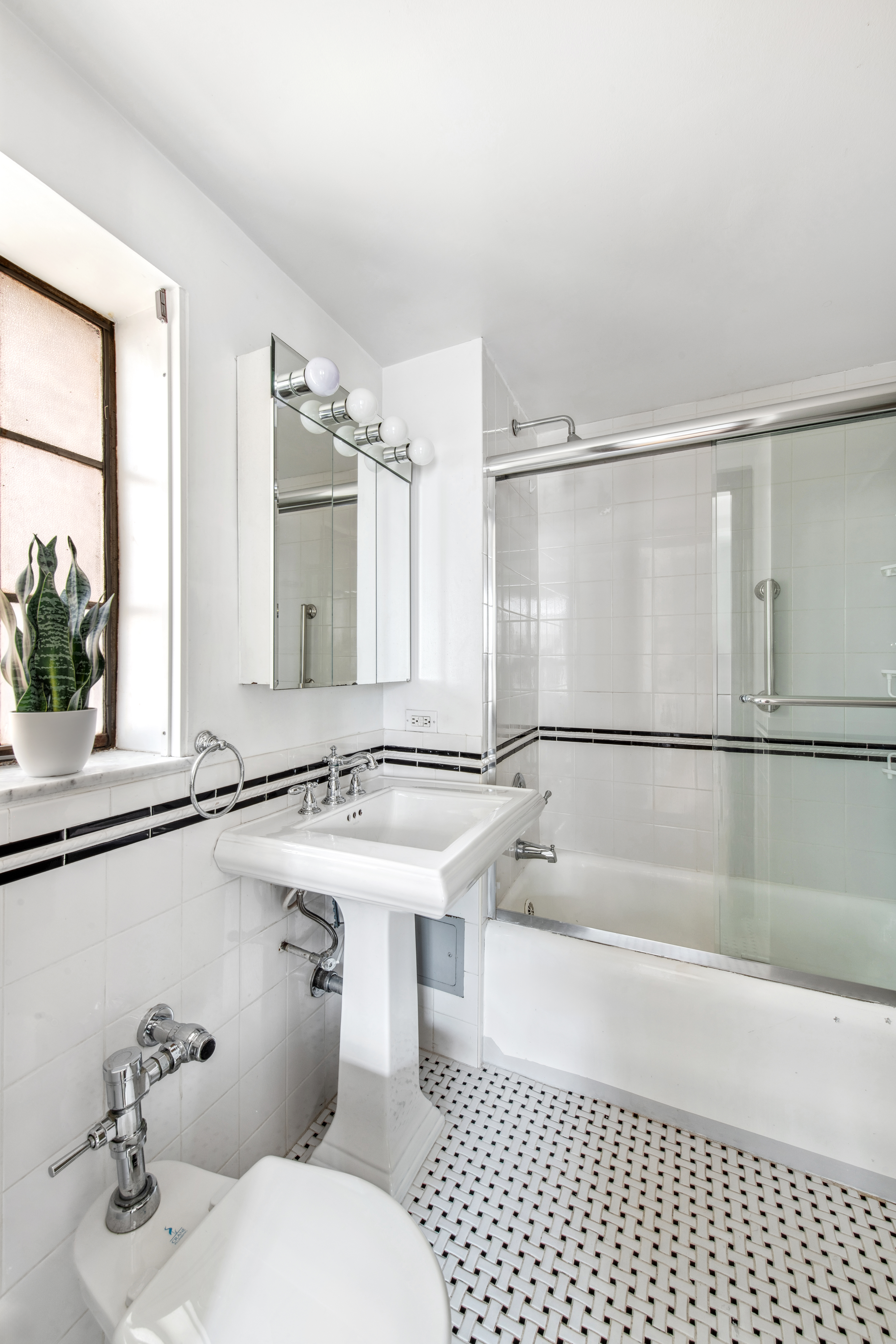 25 Tudor City Place, Unit 1419 Manhattan, NY 10017 - Photo 7 of 14 a bathroom with a sink mirror toilet and bathtub