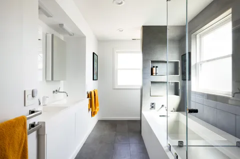 a bathroom with a tub sink and mirror