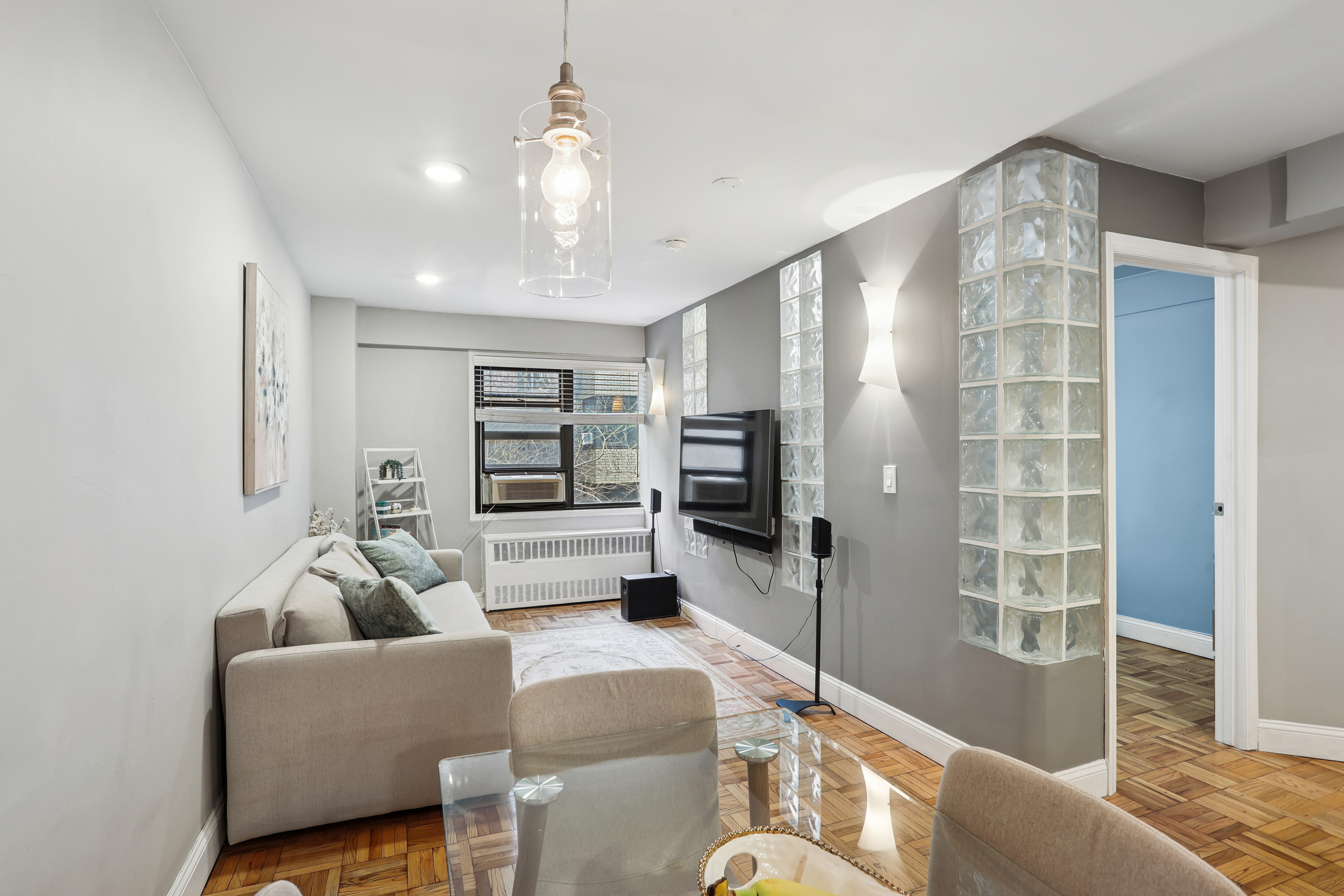 335 East 51st Street, Unit 4H Manhattan, NY 10022 - Photo 4 of 13 a living room with furniture and a flat screen tv