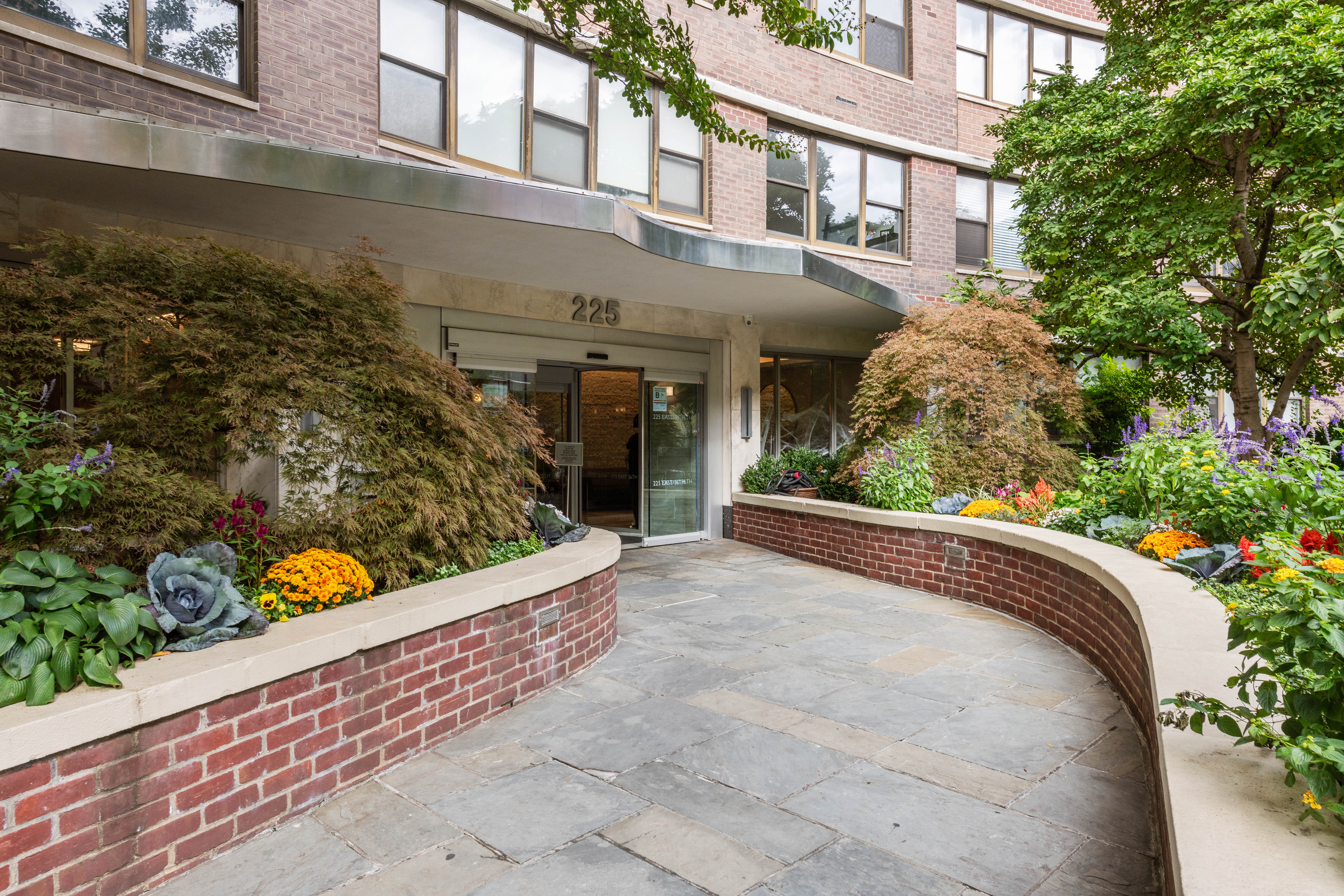 225 East 36th Street, Unit 18M Manhattan, NY 10016 - Photo 8 of 9 front view of a house with a large window and potted plants