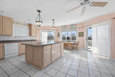 a kitchen that has a lot of white cabinets and stainless steel appliances