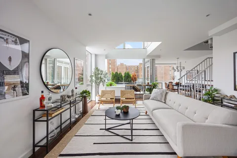 a living room with furniture a rug a fireplace and a large window