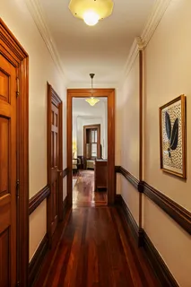 a view of a hallway with wooden floor and staircase