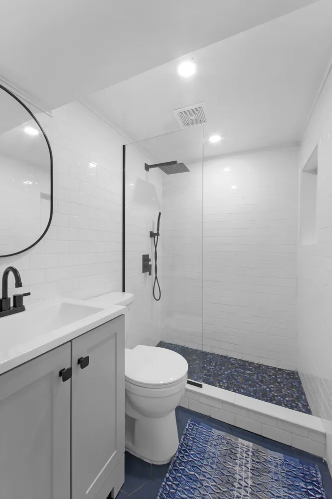 a bathroom with a granite countertop sink a toilet and shower