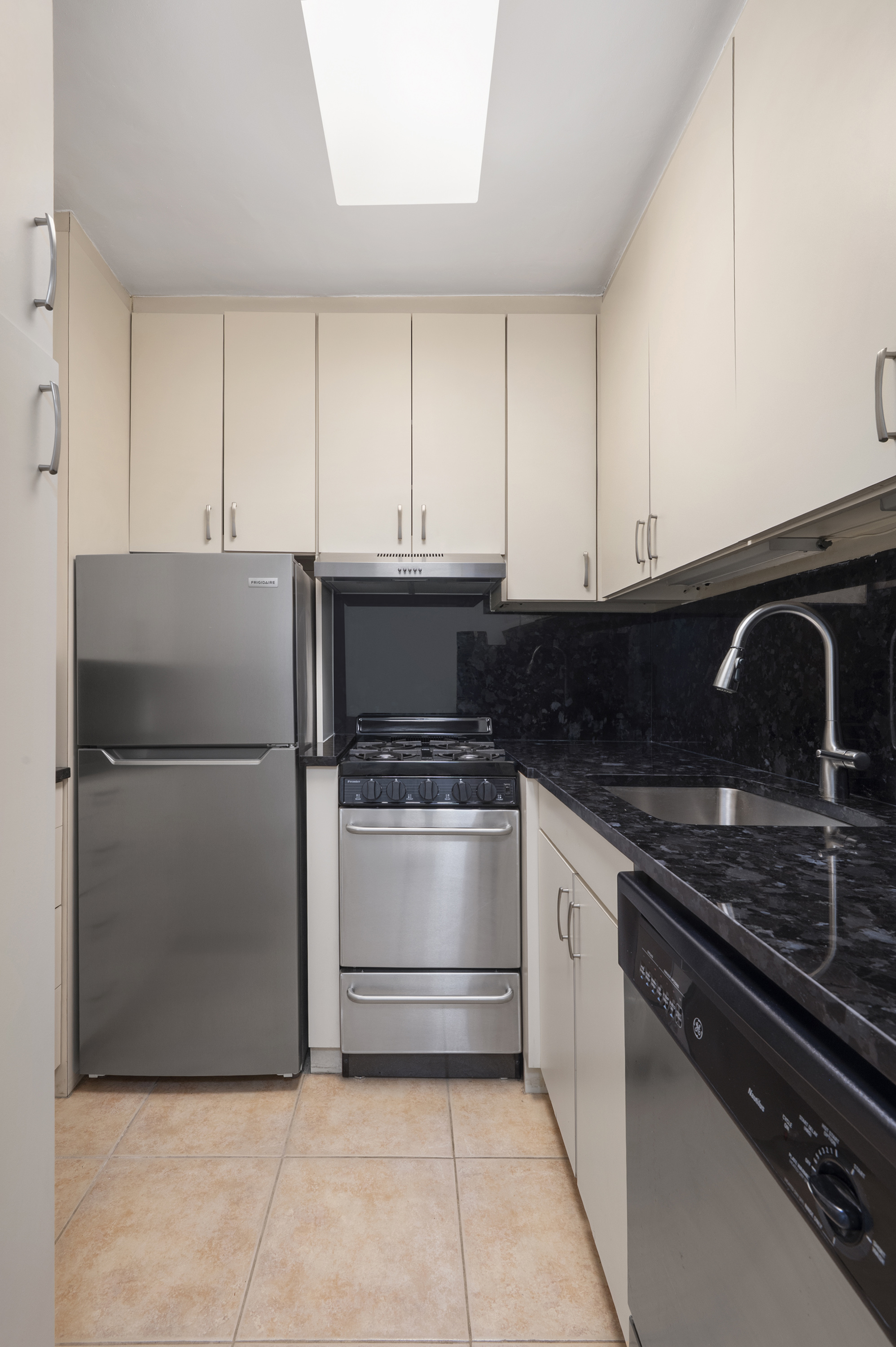 153 East 57th Street, Unit 8J Manhattan, NY 10022 - Photo 3 of 8 a kitchen with cabinets and stainless steel appliances