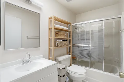 a bathroom with a sink a toilet and shower