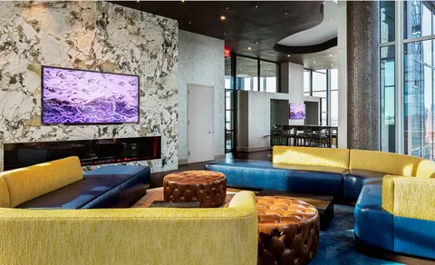 a living room with furniture and floor to ceiling windows