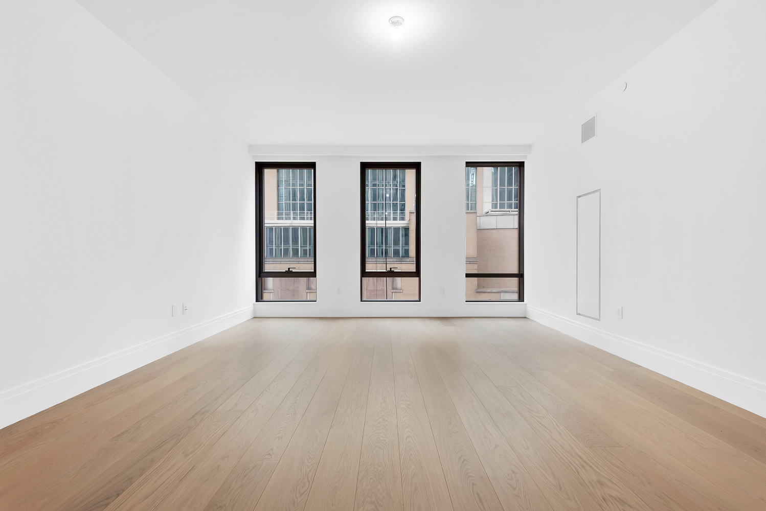 50 West 66th Street, Unit 7B Manhattan, NY 10023 - Photo 4 of 24 an empty room with wooden floor and windows