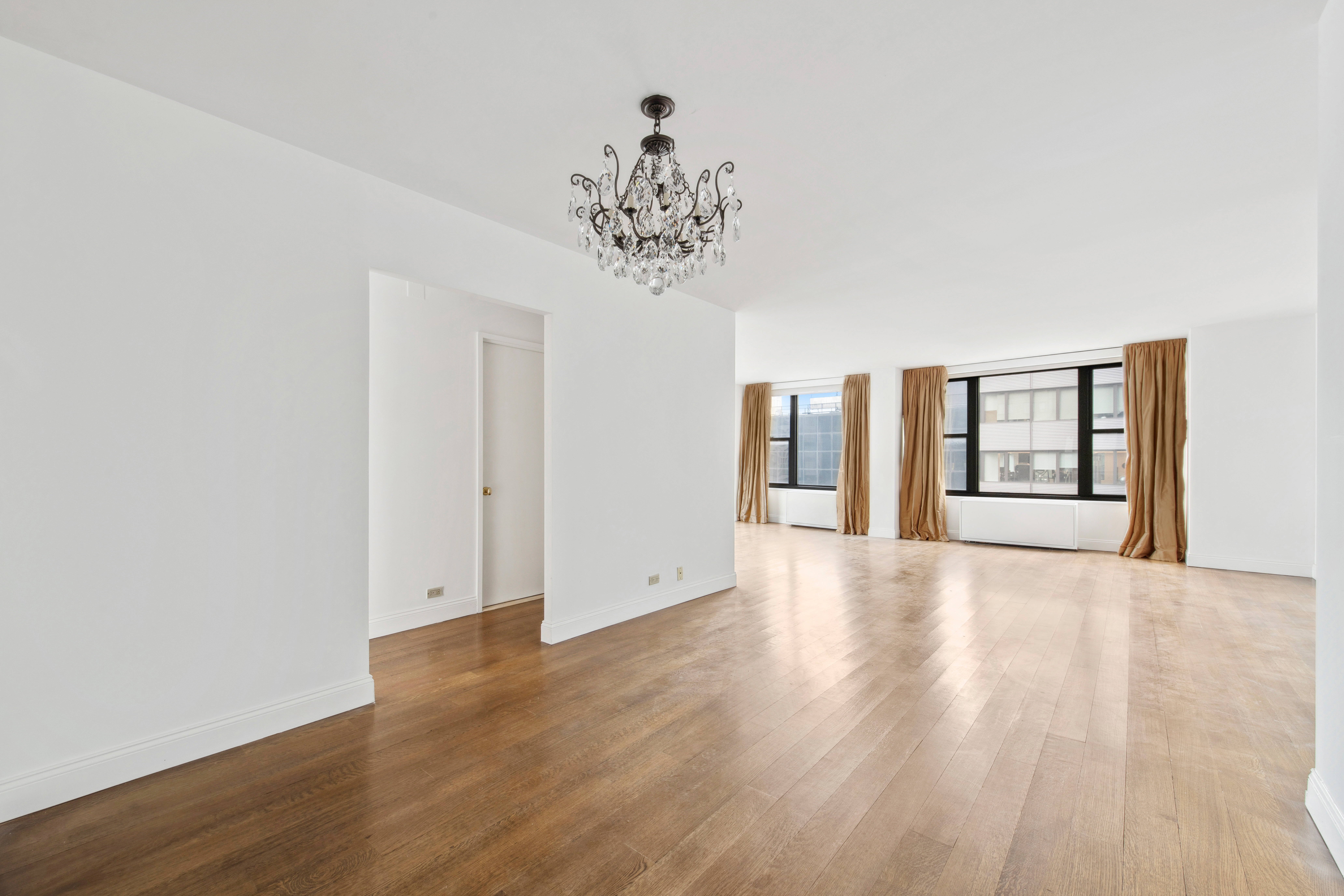117 East 57th Street, Unit 35D Manhattan, NY 10022 - Photo 4 of 30 a view of an empty room with wooden floor and a window