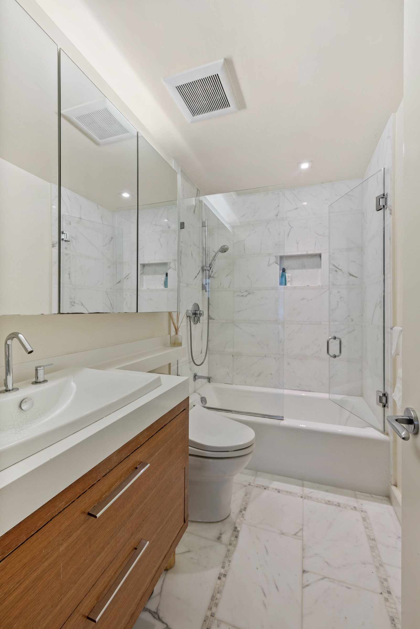 61 West 62nd Street, Unit 23G Manhattan, NY 10023 - Photo 7 of 9 a bathroom with a granite countertop sink a toilet and bathtub