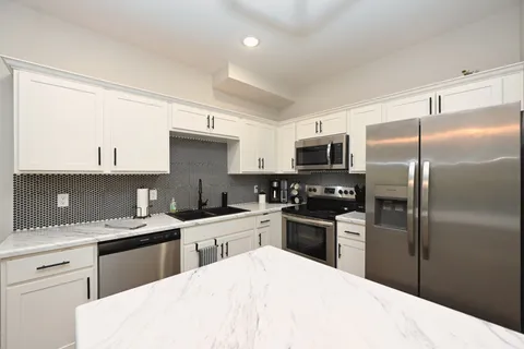 a kitchen with a sink stainless steel appliances and cabinets