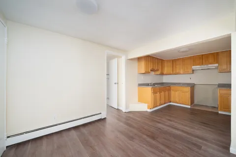 a view of empty room with wooden floor and window
