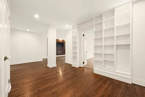 a view of empty room with wooden floor and entryway
