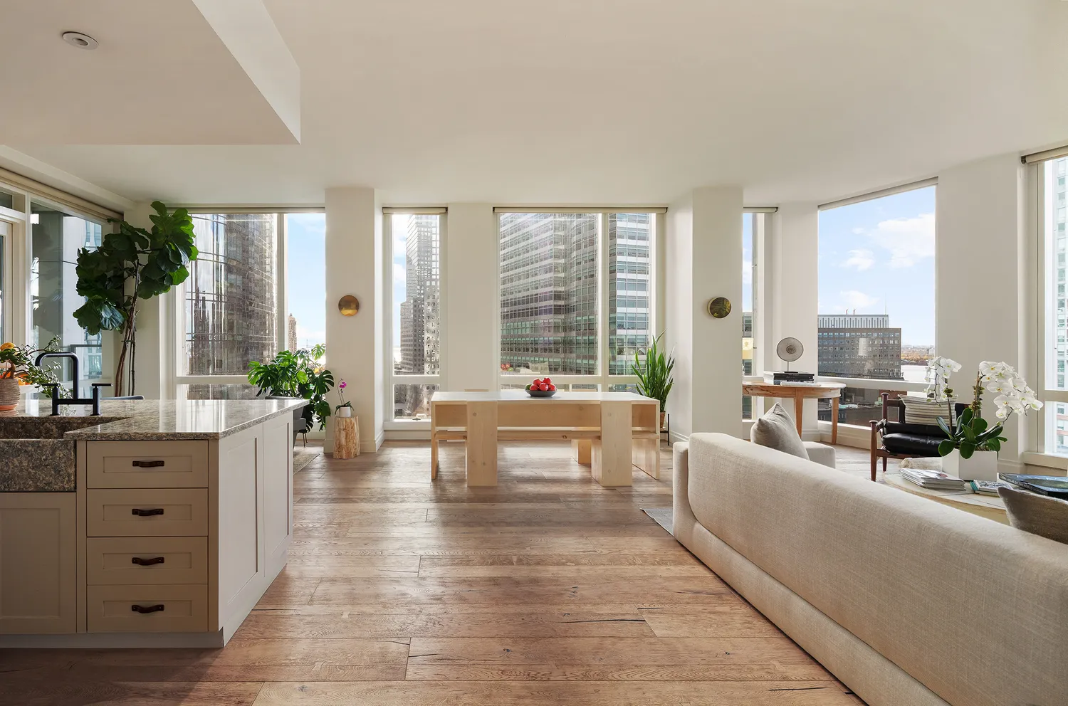 a living room with furniture large windows and wooden floor