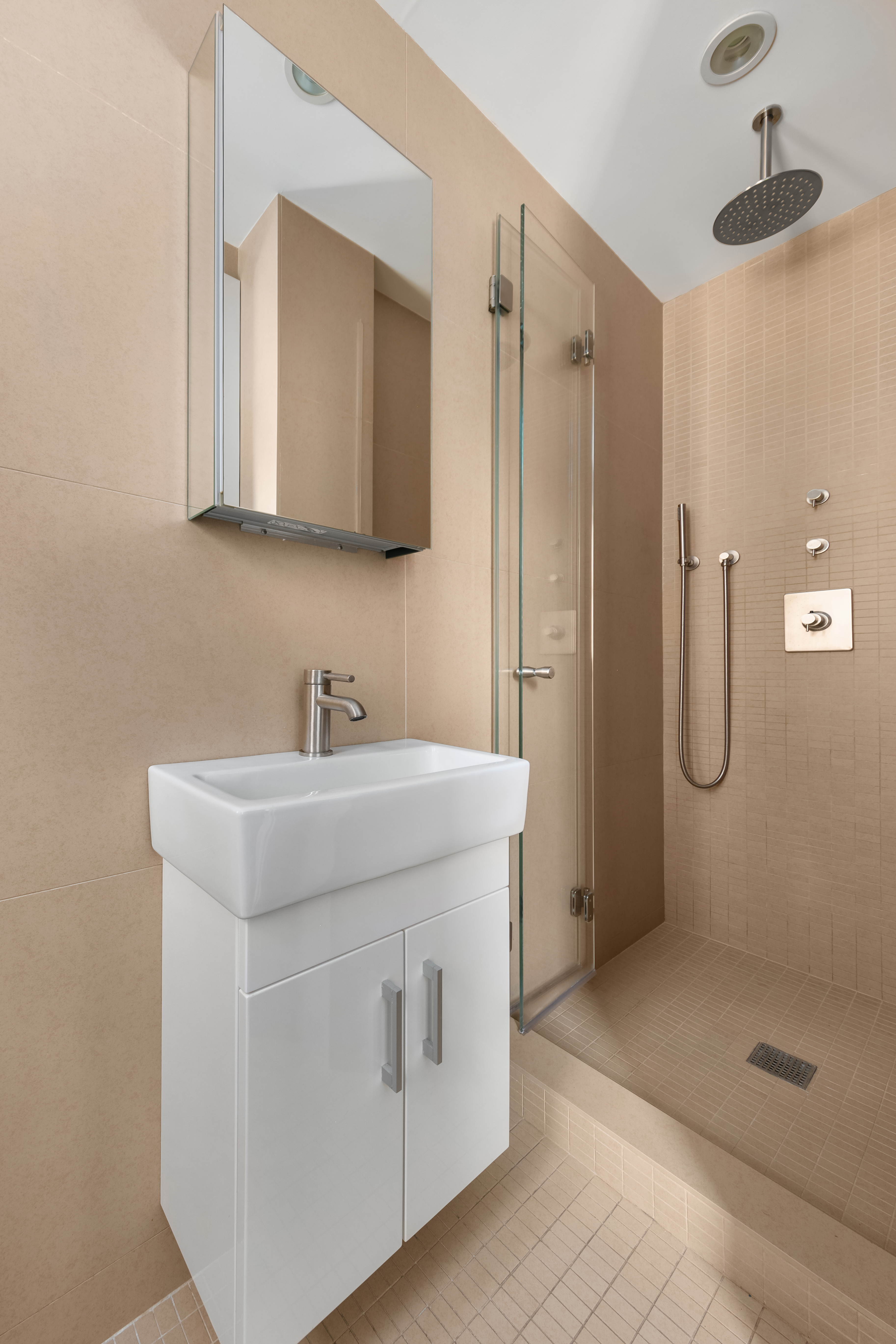 150 East 93rd Street, Unit 6AC Manhattan, NY 10128 - Photo 12 of 17 a bathroom with a shower sink and mirror