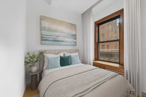 a bedroom with a bed and a painting on the wall