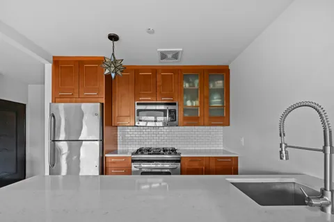 a kitchen with stainless steel appliances granite countertop a refrigerator and a sink
