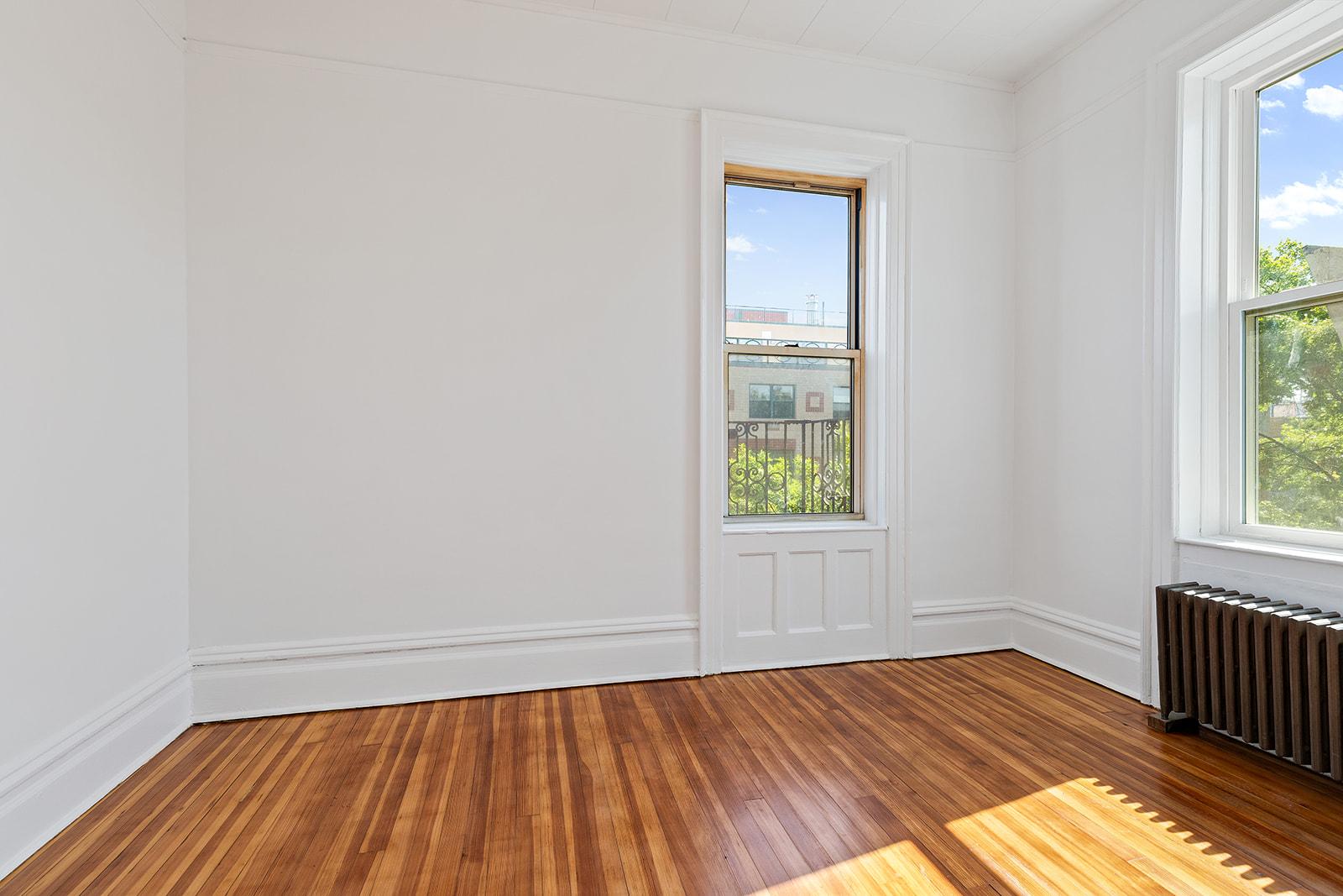 4401 4th Avenue, Unit D4 Brooklyn, NY 11220 - Photo 3 of 7 an empty room with wooden floor and windows