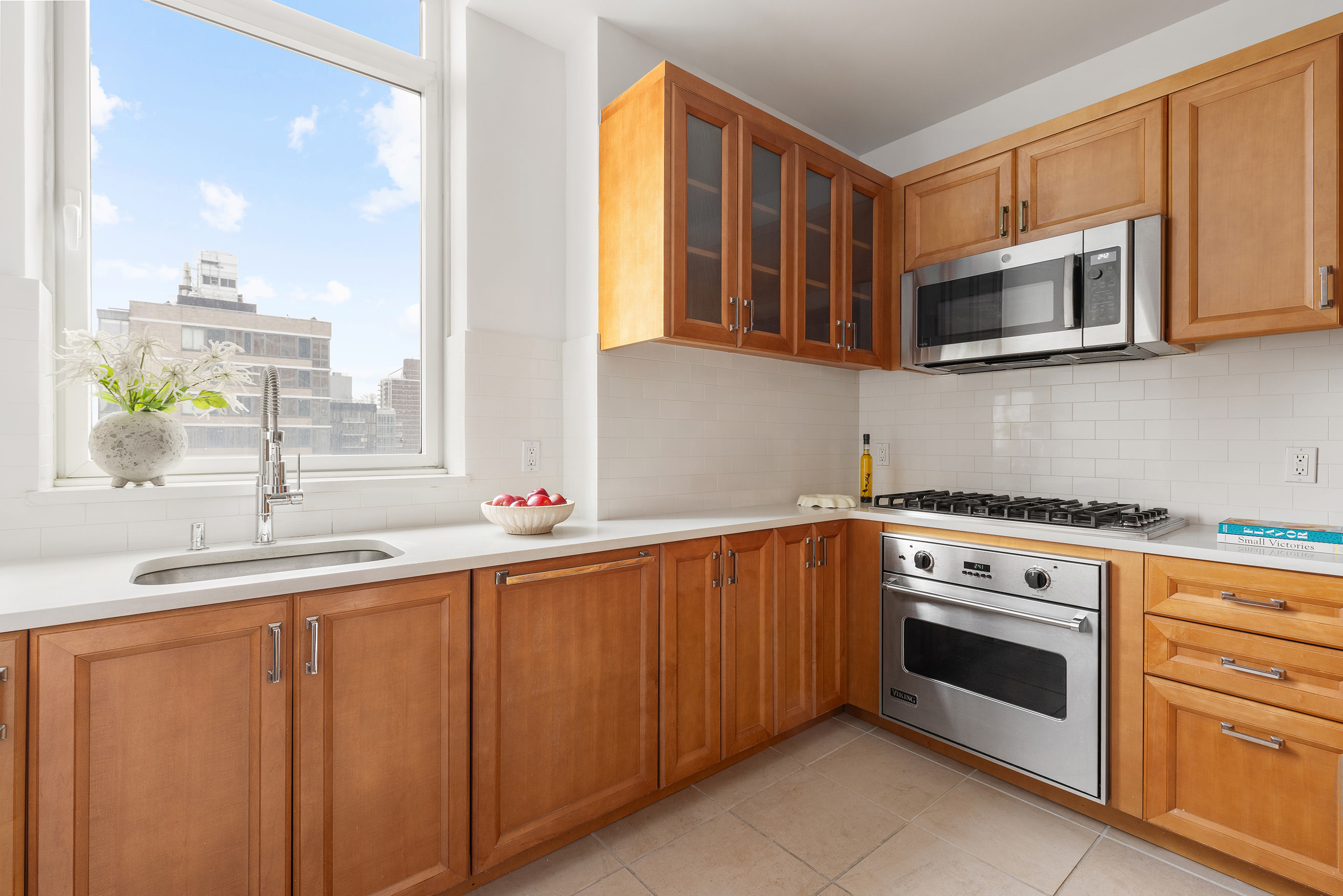 205 East 85th Street, Unit 19B Manhattan, NY 10028 - Photo 3 of 9 a kitchen with stainless steel appliances a stove microwave and sink