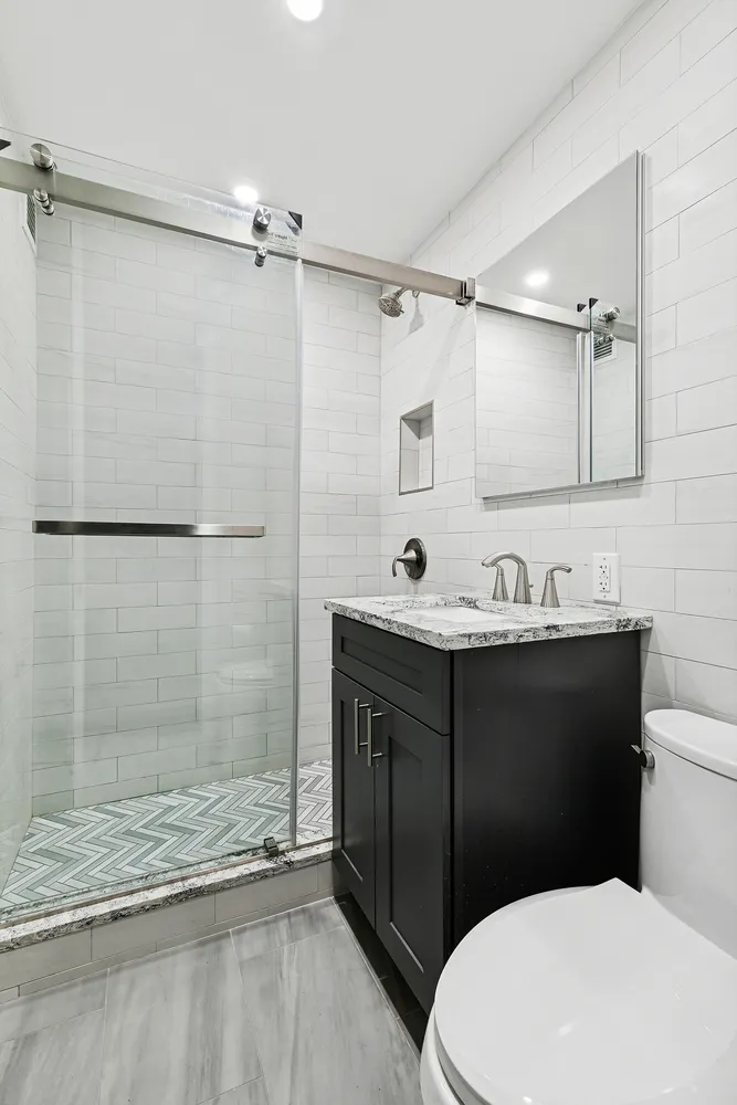 a bathroom with a sink vanity granite and toilet