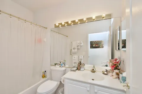 a bathroom with a sink mirror vanity and toilet