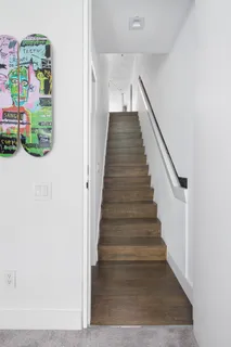a view of entryway with lots of frames on wall and wooden floor