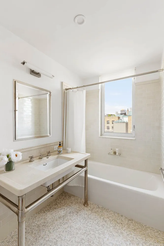 a bathroom with a tub sink and mirror