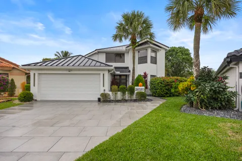 a front view of a house with a garden and a garage