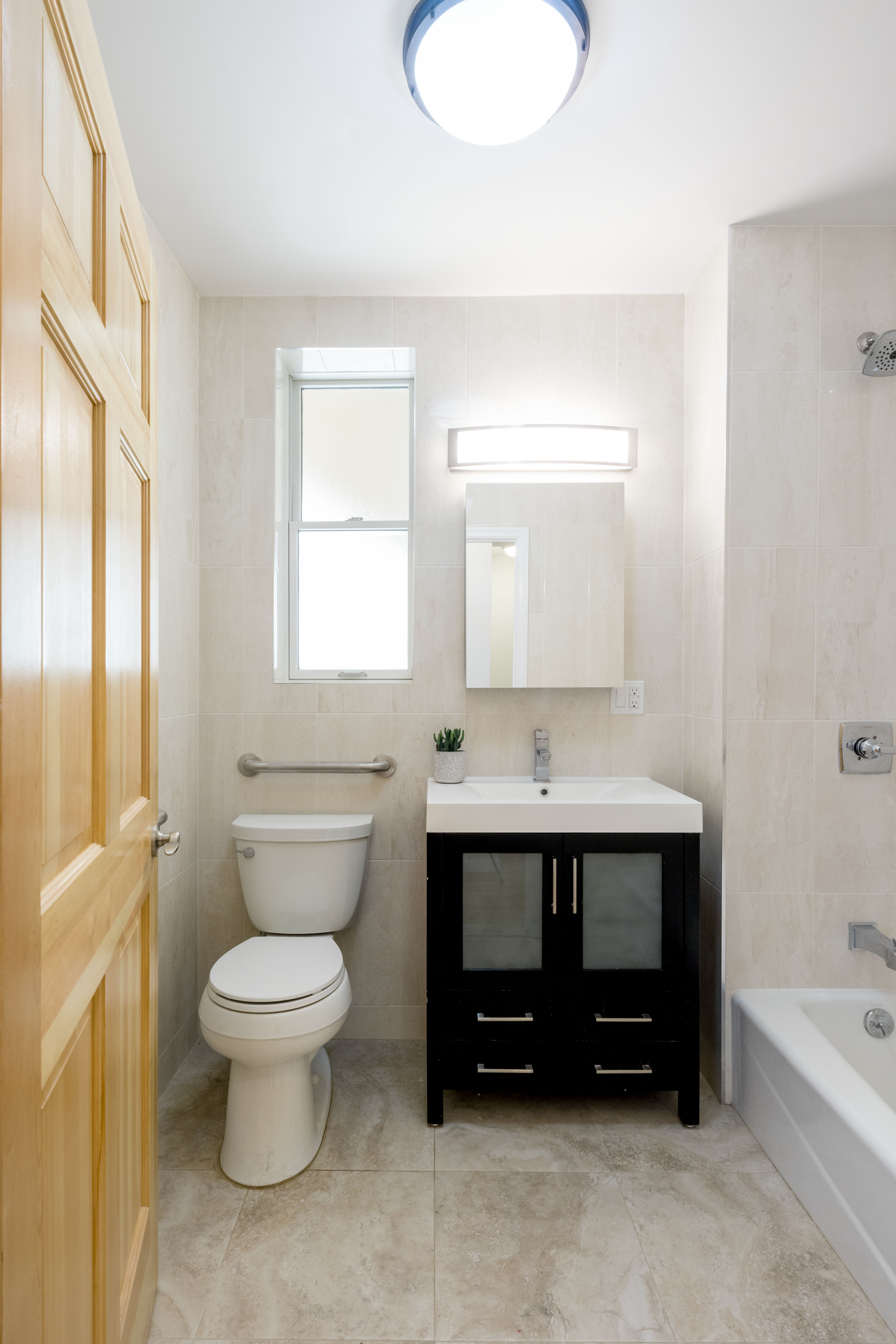 18-10 Astoria Park South, Unit 1 Queens, NY 11102 - Photo 5 of 6 a bathroom with a sink toilet a mirror and bathtub