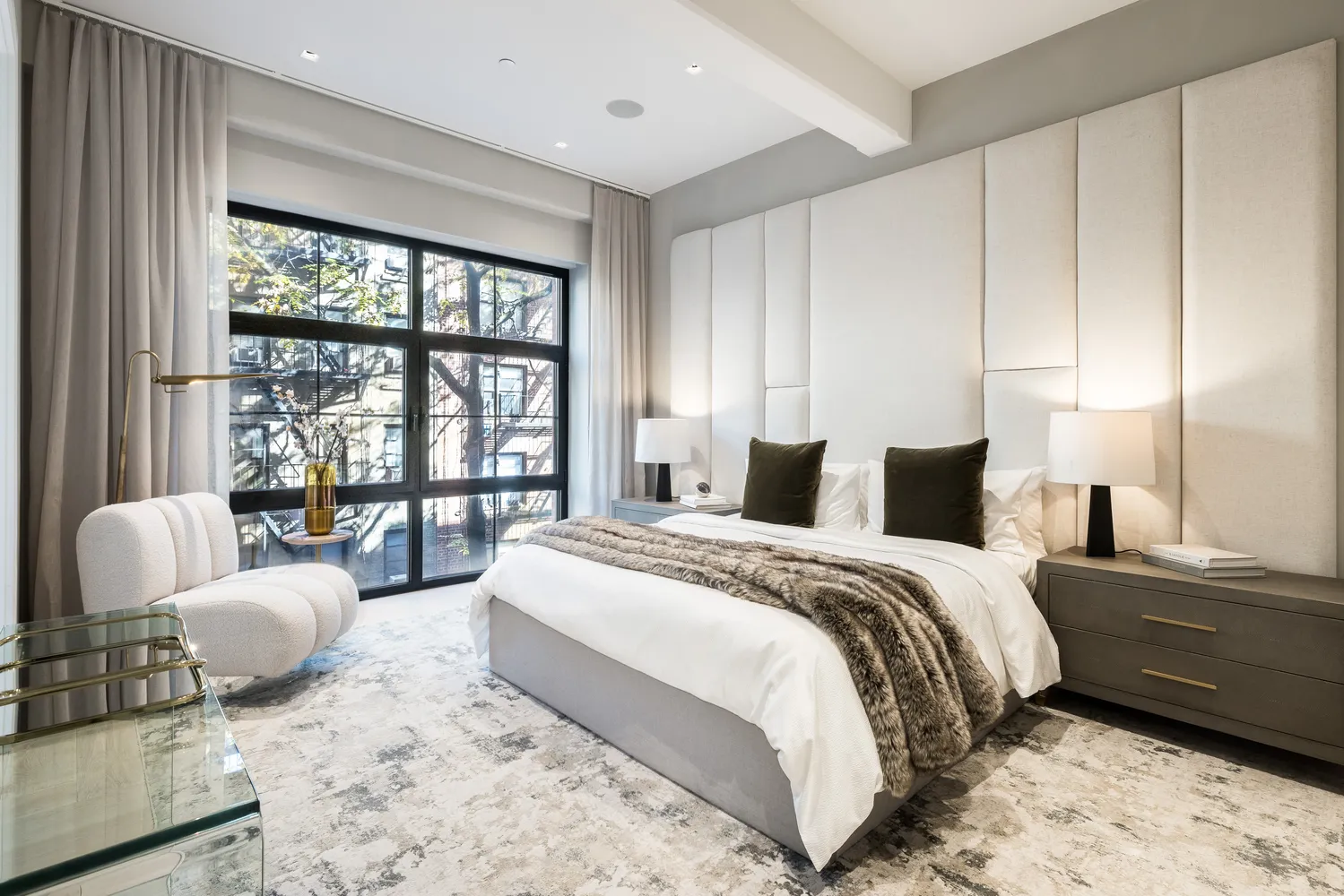 a bedroom with a bed couch and a large window