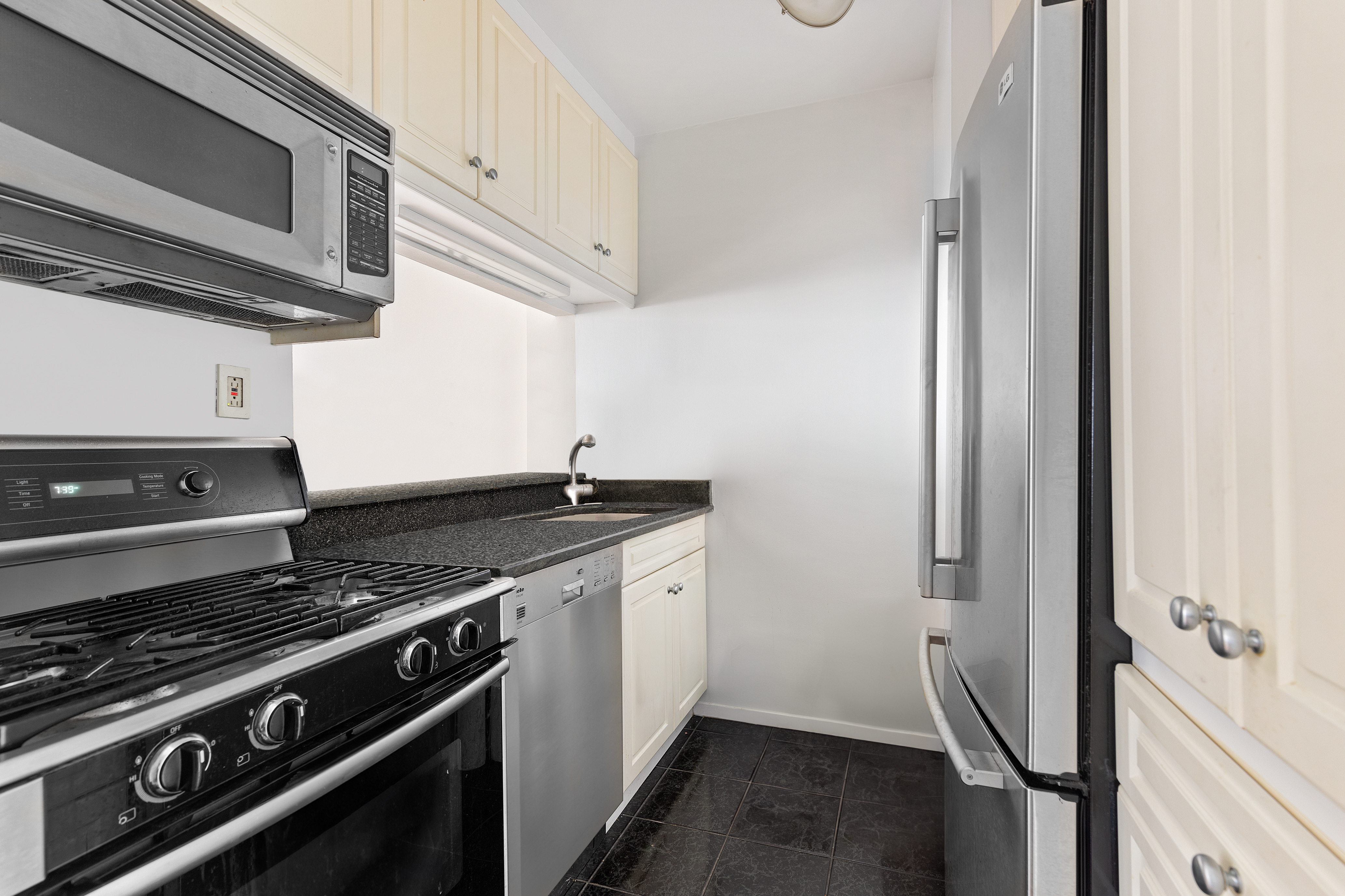 2000 Broadway, Unit 8I Manhattan, NY 10023 - Photo 4 of 9 a kitchen with a stove and a microwave