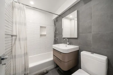 a bathroom with a toilet sink and mirror
