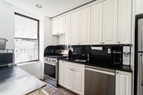 a kitchen with granite countertop a stove a sink and a granite counter tops