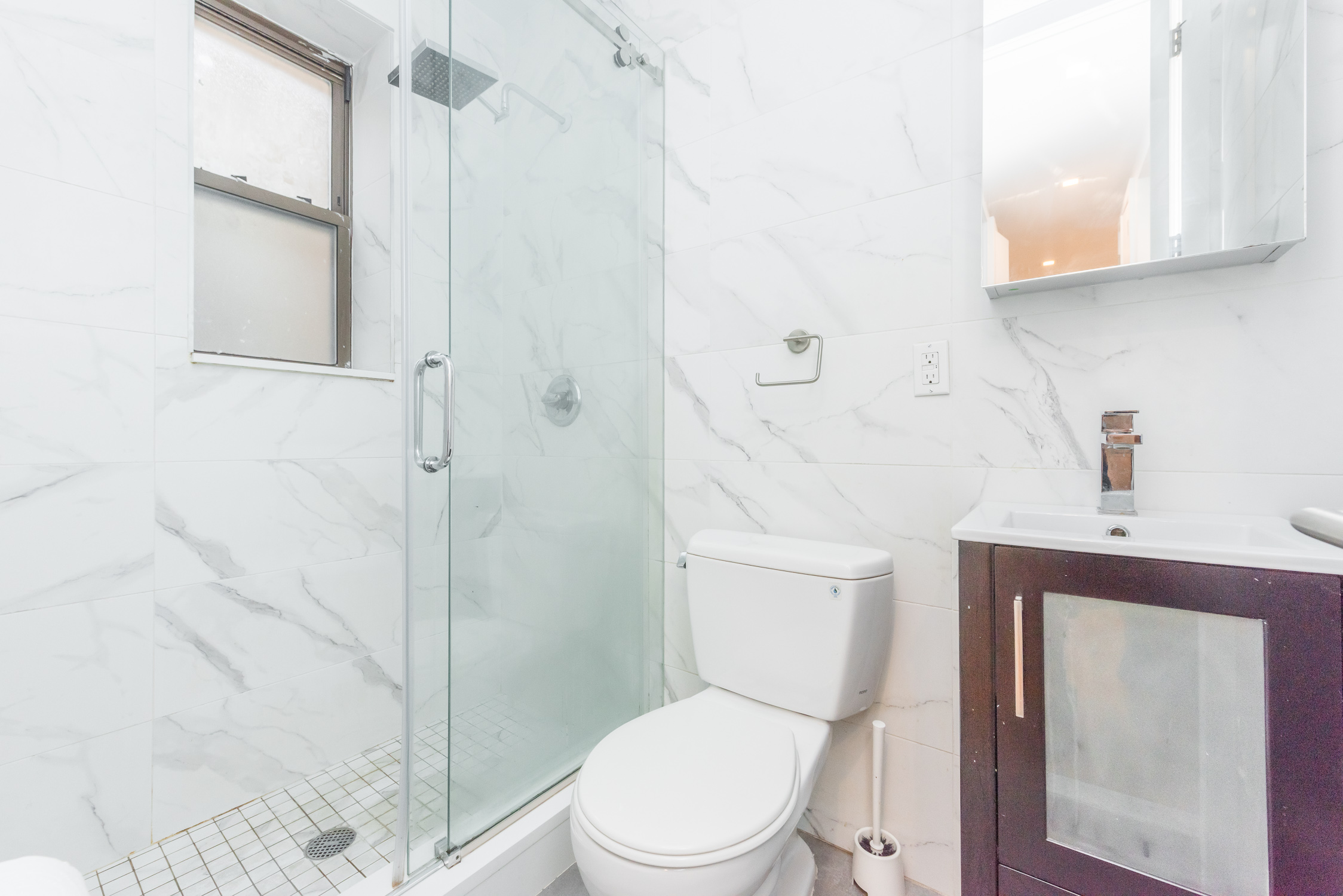 22-11 Steinway Street, Unit 3R Queens, NY 11105 - Photo 5 of 9 a white toilet sitting next to a bathroom sink