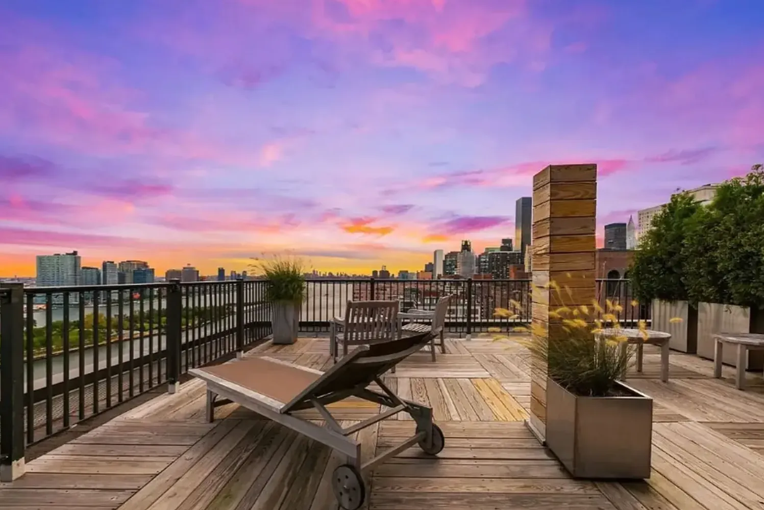 a view of a rooftop deck with chairs and wooden floor